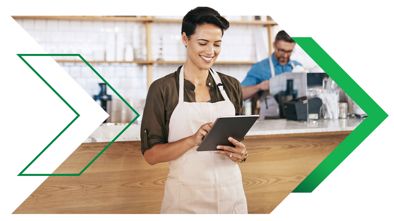 Coffee shop worker reviewing time and attendance on tablet